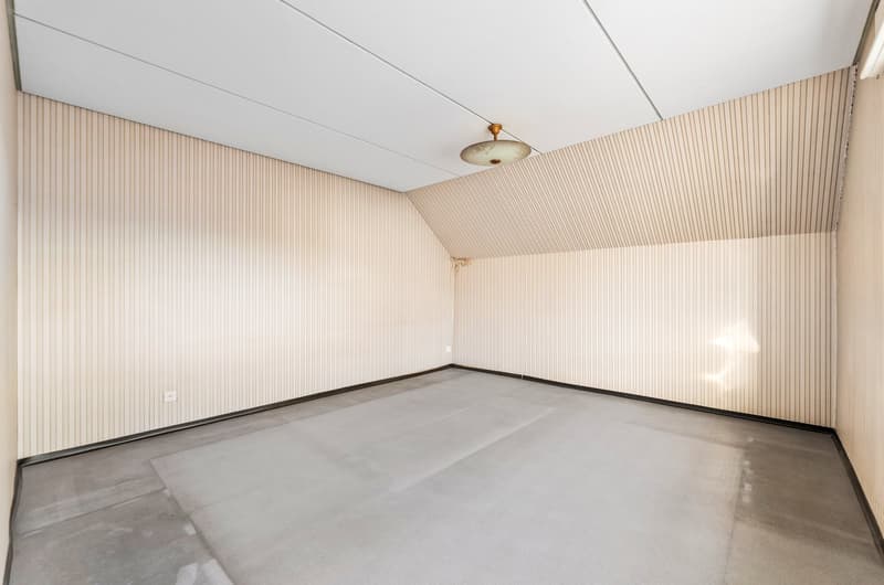 empty room with white walls, gray floor, ceiling lamp