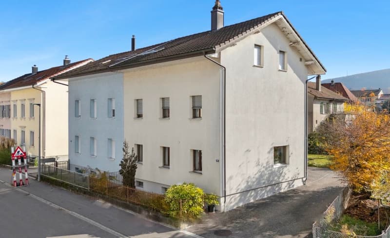 2 story apartment building, white exterior, multiple windows, brown roof