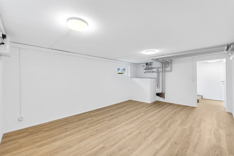 empty room, white walls, wooden floor, ceiling lights, small window, electrical outlets