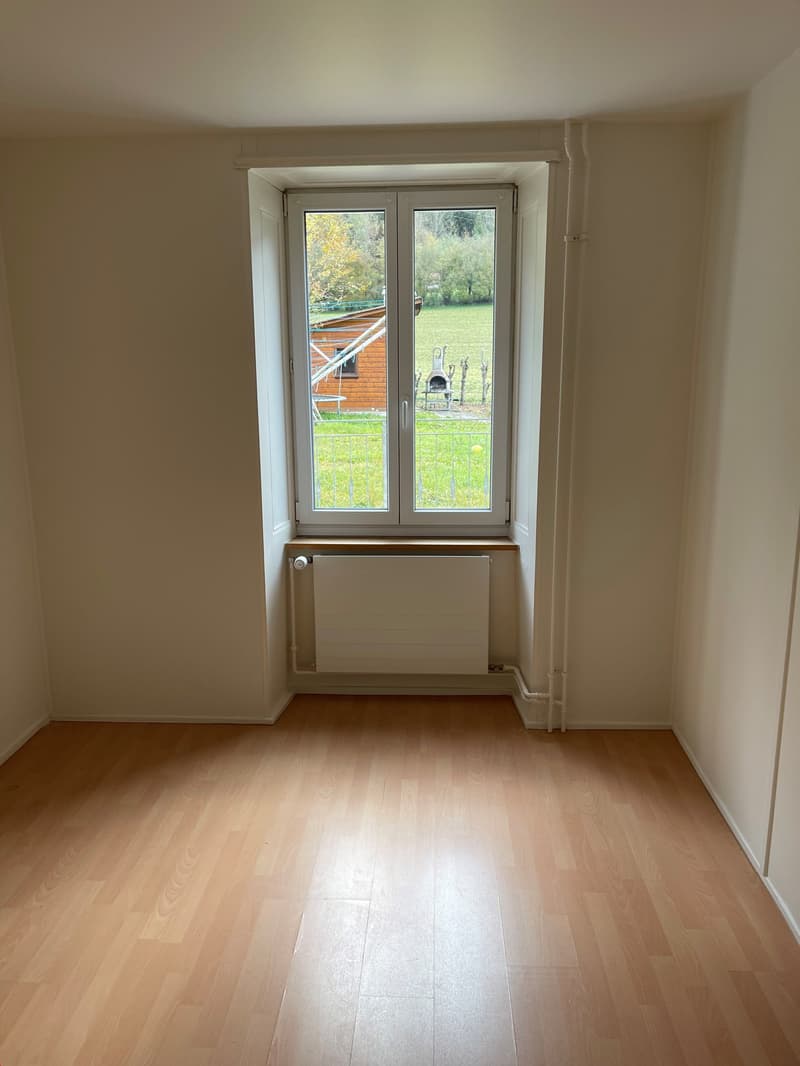 empty room, large window, radiator, wooden floor, natural light from the window