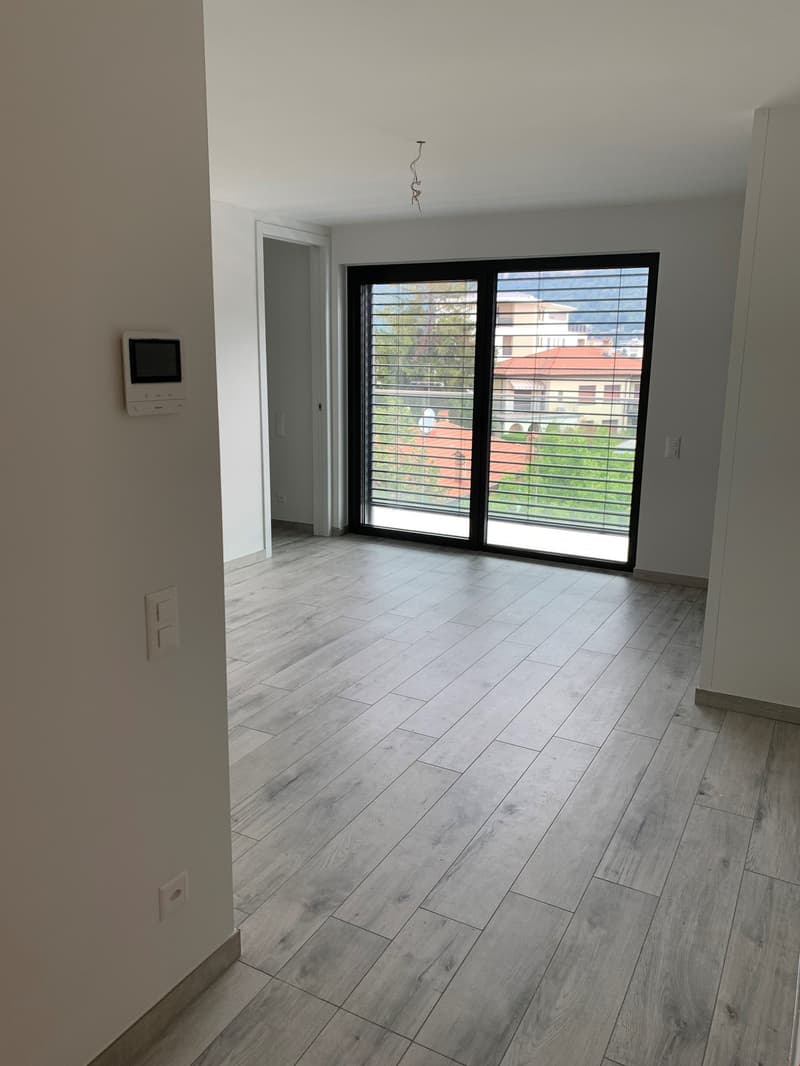 empty room, wooden floor, sliding glass door, balcony, white walls, power outlets, intercom