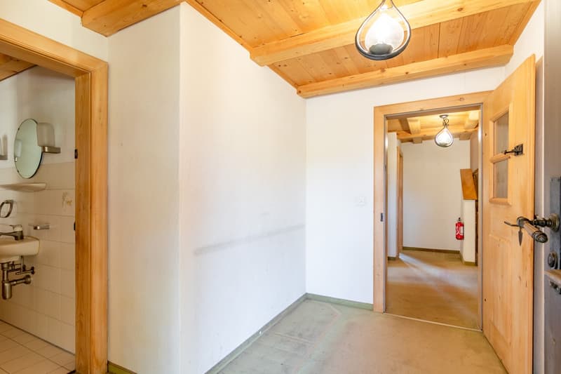 Bathroom with white tiles, wooden ceiling, sink, mirror, and a fire extinguisher