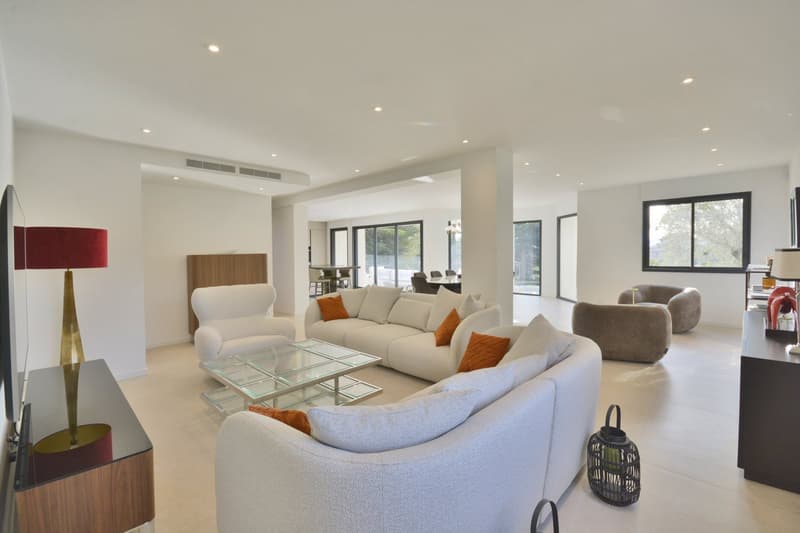 modern living room with white furniture, glass coffee table, large windows, TV, lamps