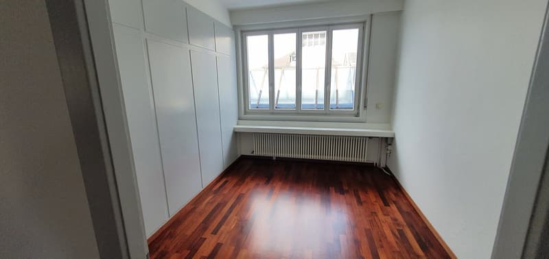 Spacious bedroom with large windows, built-in wardrobes, and hardwood flooring