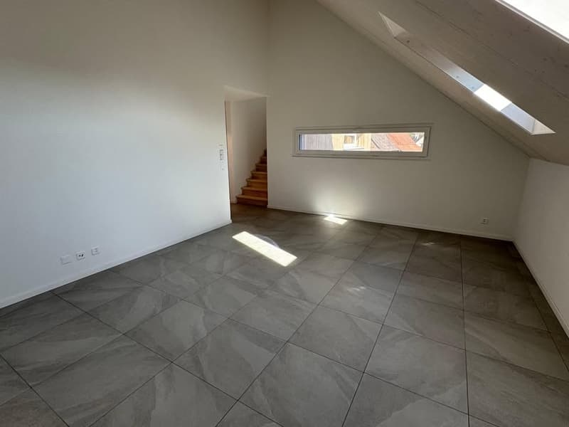 Empty room, tile flooring, white walls, power outlets, skylights, doorway, and staircase leading to upper level.