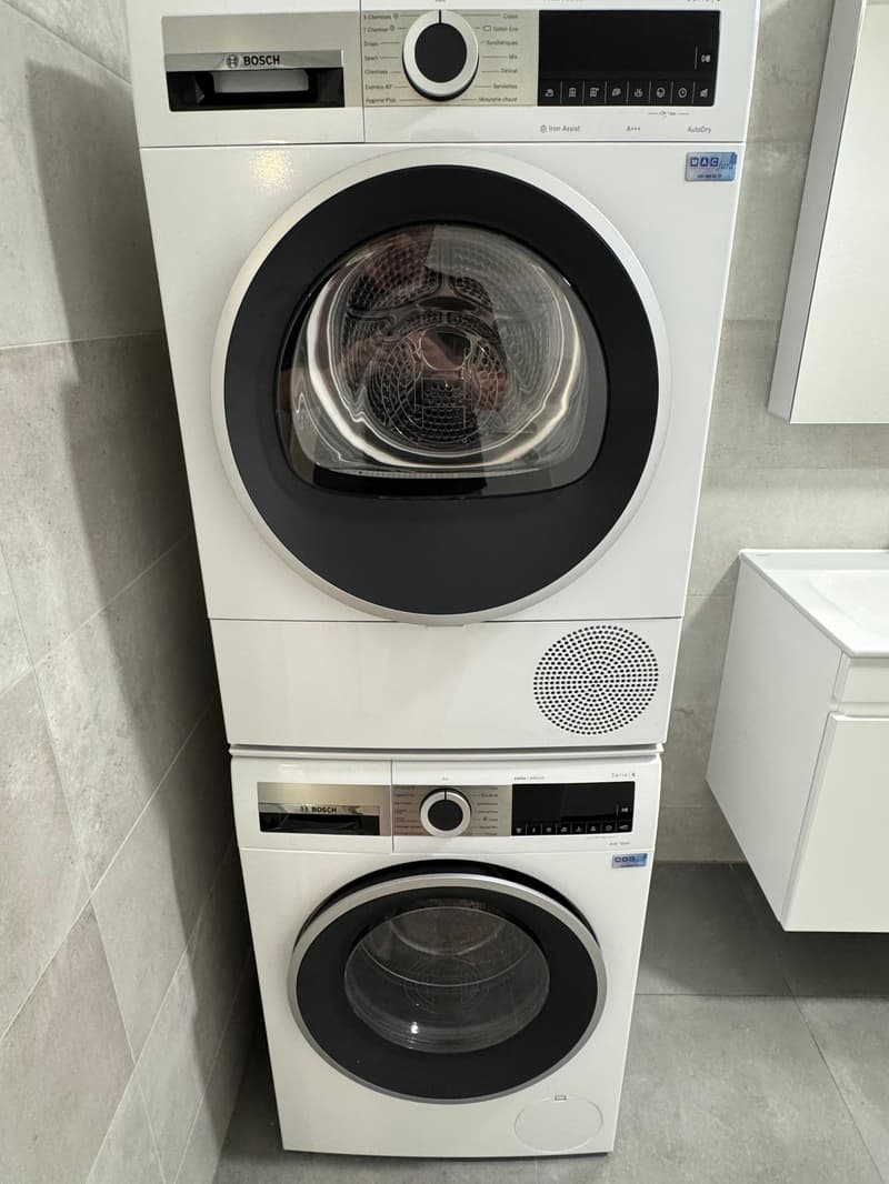 Stacked washing machine and dryer, both white, with a Bosch brand