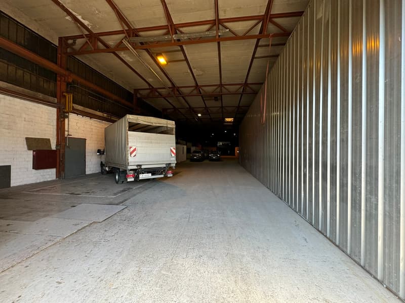 industrial space, concrete floor, open area, truck parked, metal walls, large open space