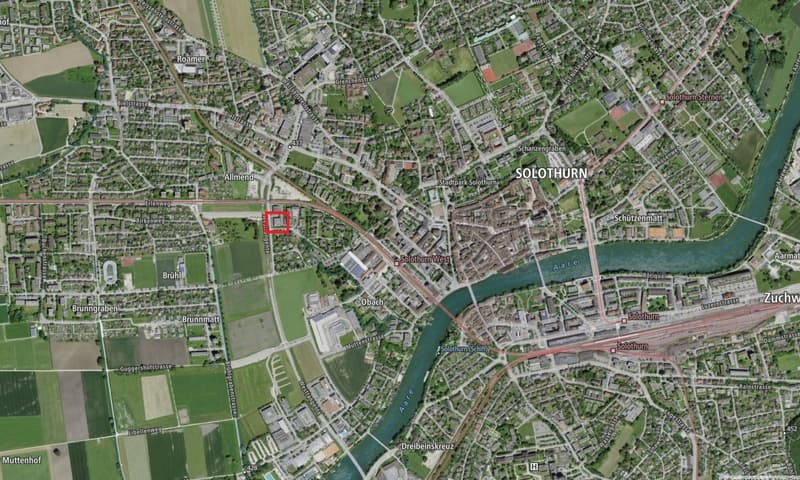 Aerial view of a town named Solothurn. Includes roads, railways, green areas, and a river.