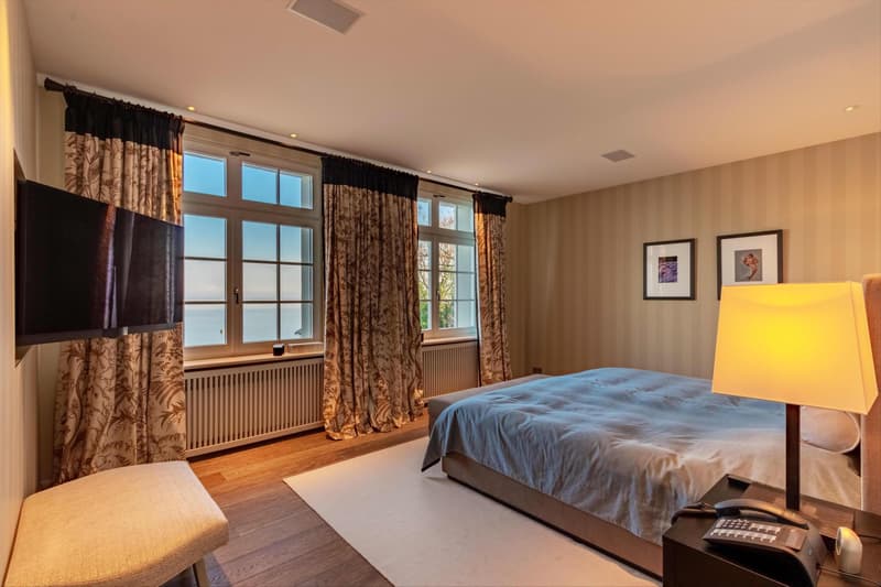 Grosszügiges Schlafzimmer mit einzigartigem Ausblick auf den Bodensee. Die Hauptwohnräume begeistern durch ihre herrliche Ausrichtung zum See und schaffen ein unvergleichliches Wohngefühl