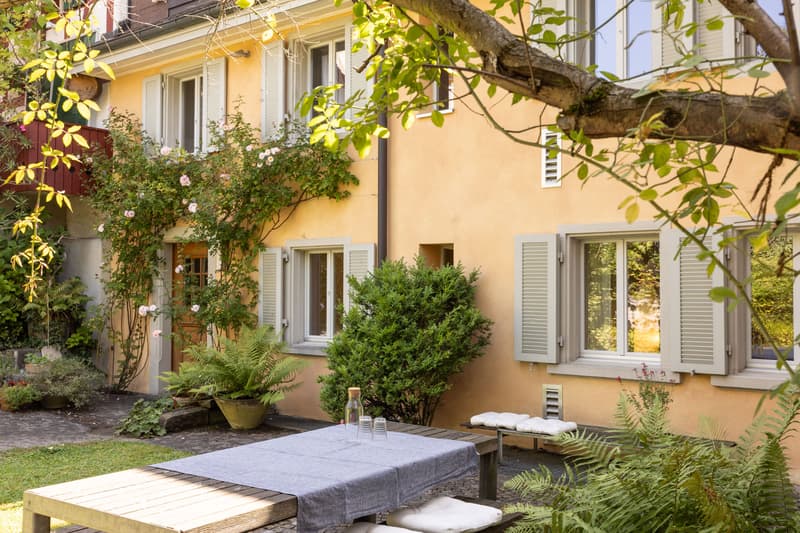 Der ruhige Gartensitzplatz lädt, umgeben von sattem Grün, zum Verweilen ein.