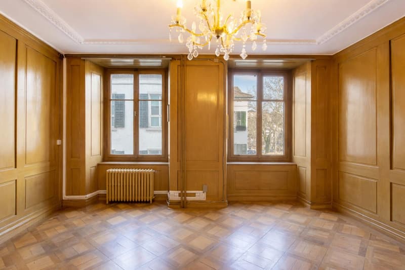 Räume mit warm wirkender Holzvertäfelung und Parkettböden.
