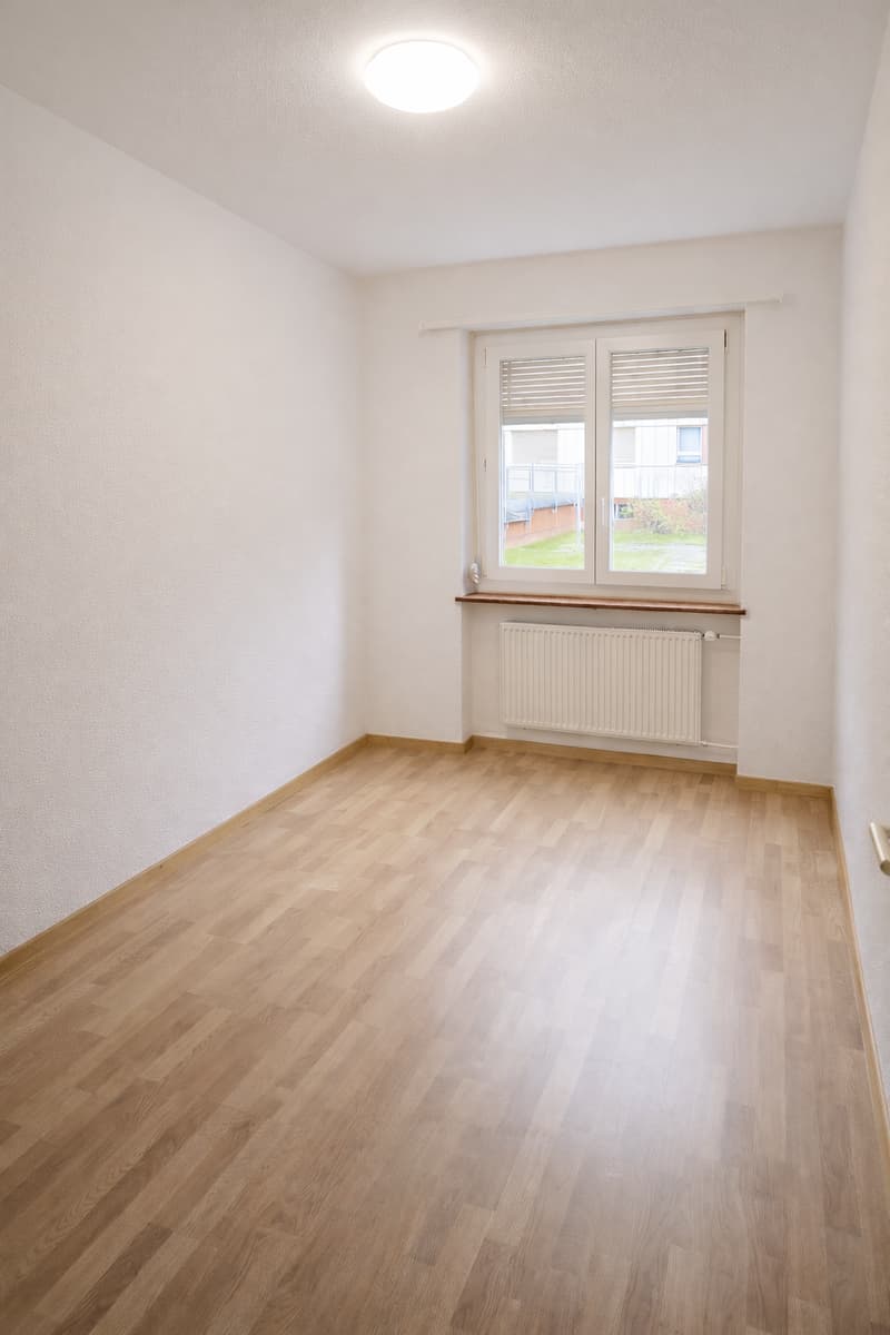 white walls, wooden floor, white ceiling, radiator, window