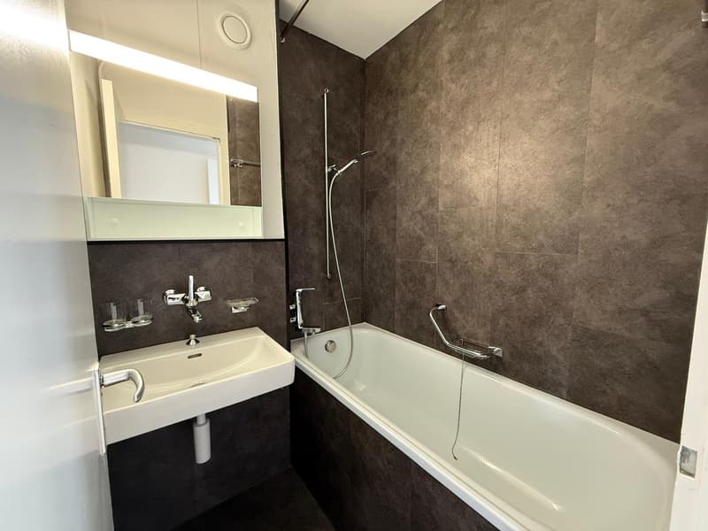 Bathroom with bathtub, sink, mirror, and shower head