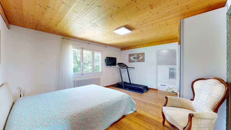 Bedroom with bed, treadmill, television, and chair.