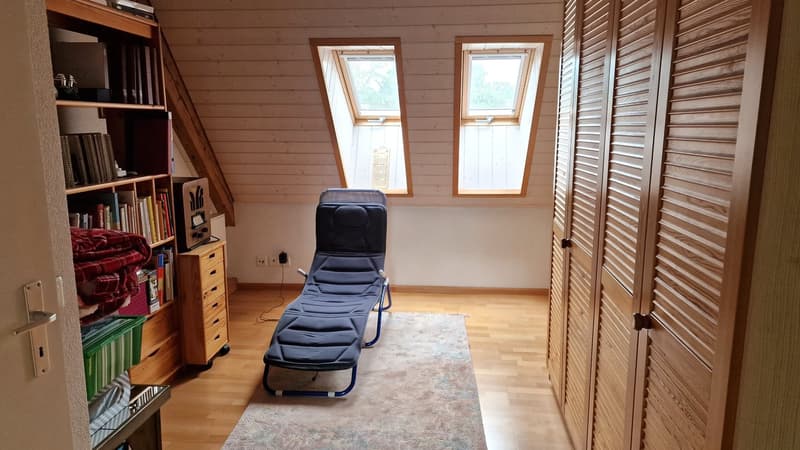 bedroom with wooden floor, blue lounge chair, carpet, shelves, drawers, power outlets, wooden wardrobe