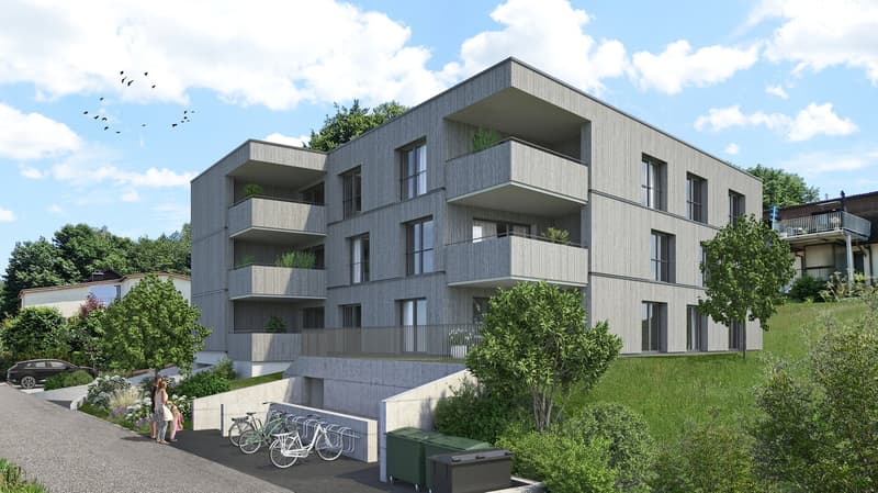 Multi-storey building, gray facade, modern design, multiple balconies with plants, sloped area with grass and trees, bicycles parked in front, two people walking near bicycles