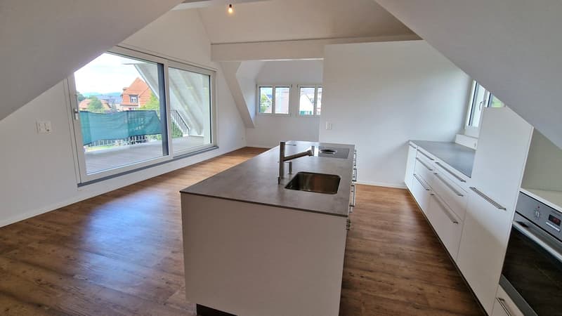 Kitchen with double sink, island countertop, sliding doors leading to balcony, raised ground floor
