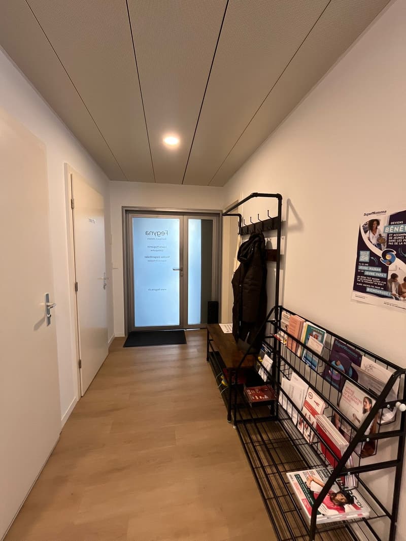 wooden floor, white walls, glass door, bench, coat rack, magazine rack, poster