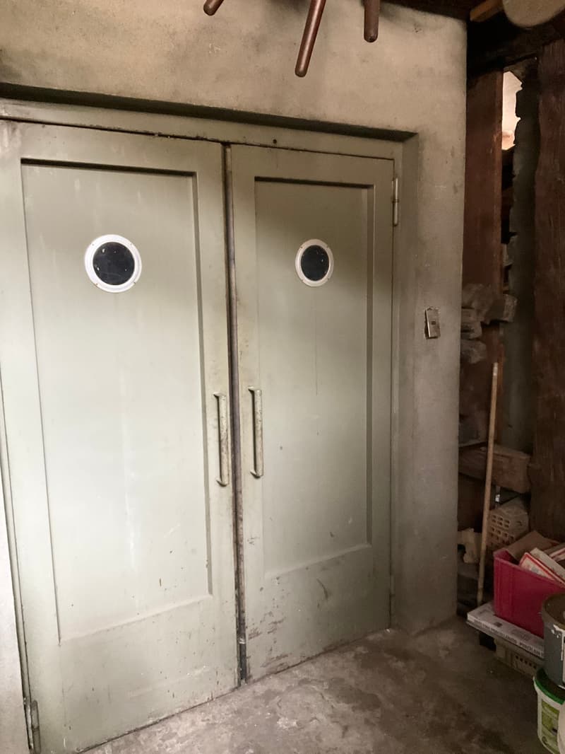 Double metal doors, small windows, storage box and broom