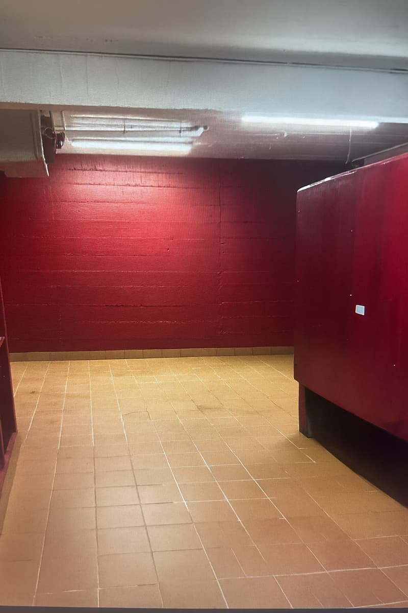 Red walls, tiled floor, ceiling light, empty room