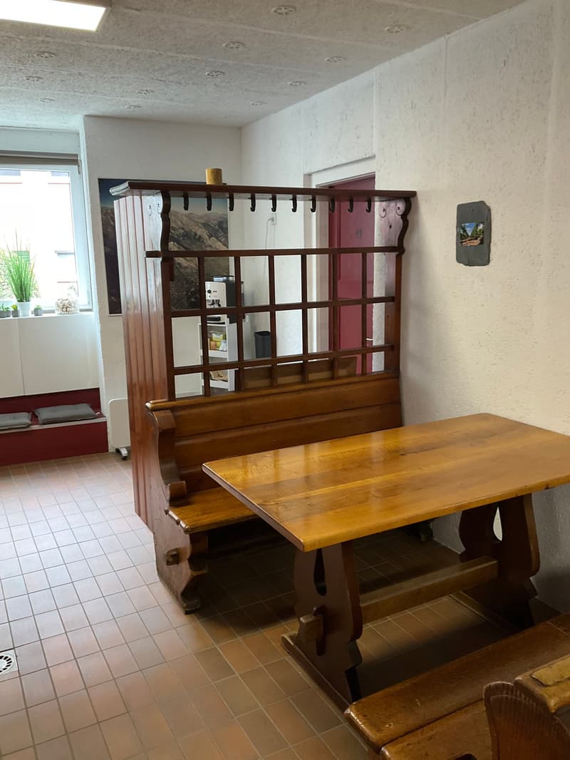 Wooden bench, large wooden table, red tiled floor, picture on wall