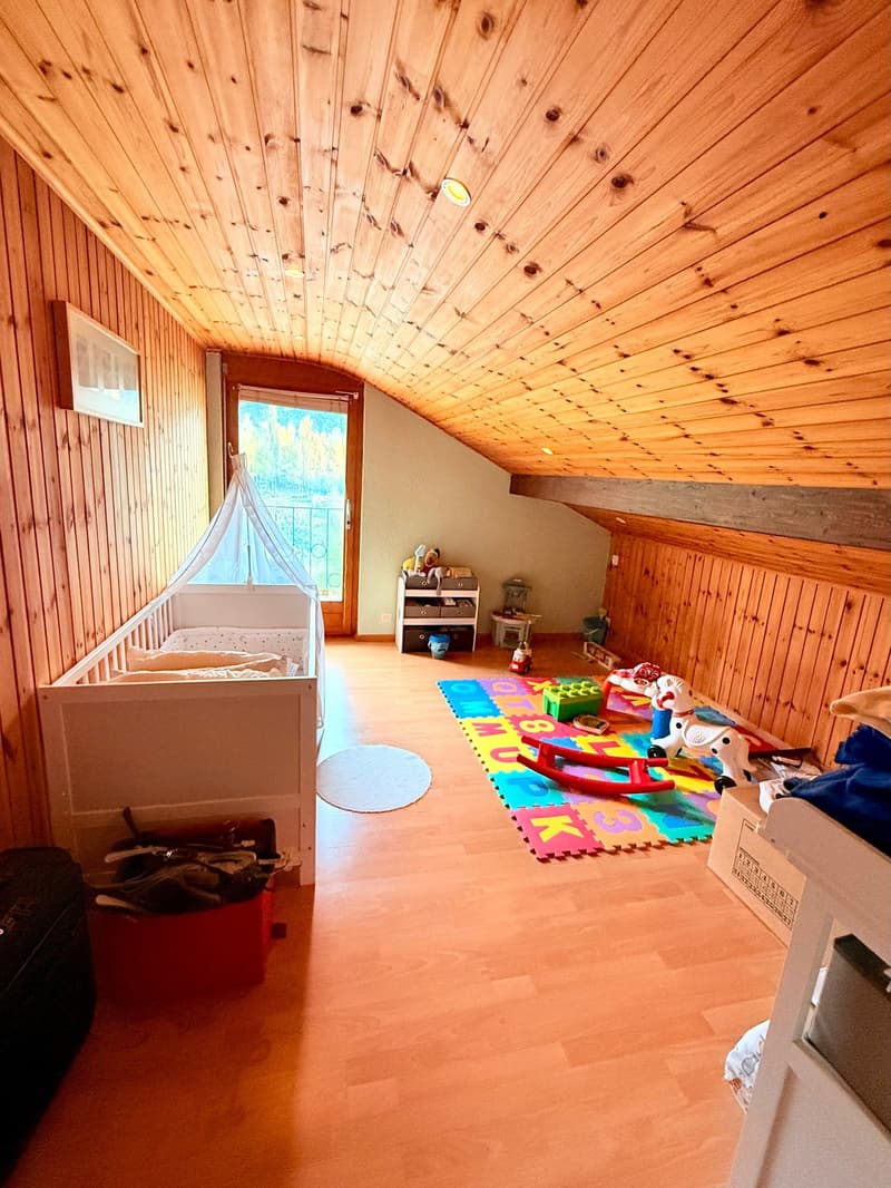 Child room with wooden walls, crib, toys, floor toys, picture on wall, rug, doorway, window