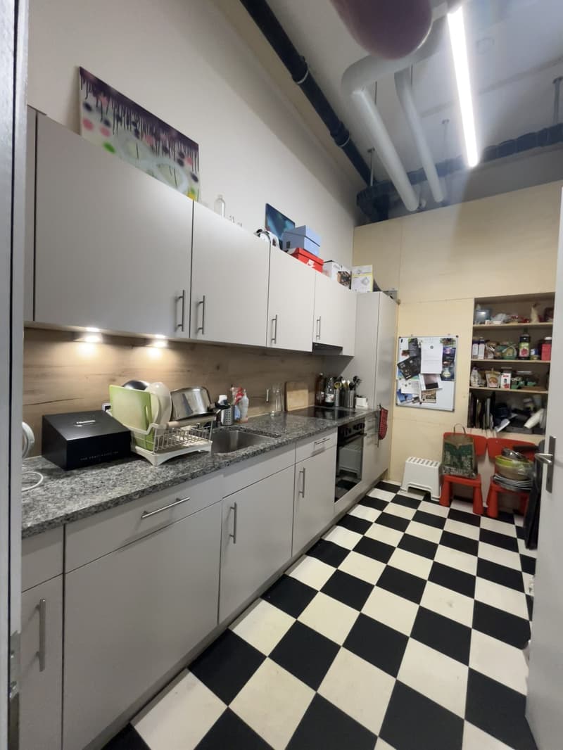 Modern white cabinets, marble countertop, black and white checkered floor, sink, stove, dishwasher