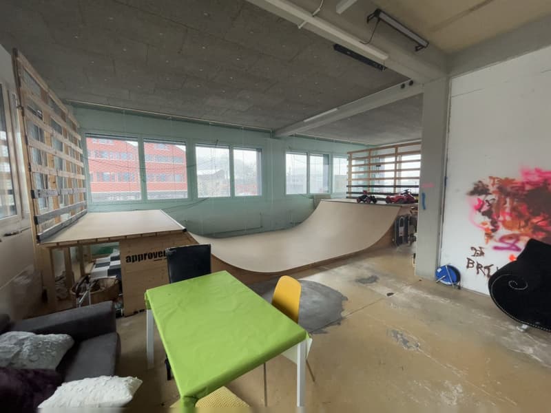Indoor skate park with skate ramp, chairs, table, couch, and baskets