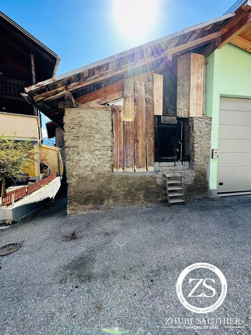 Stone house, wooden roof, wooden door, garage, concrete driveway, wooden fence