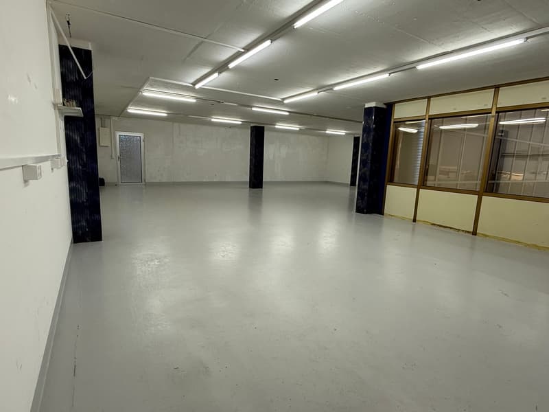 Warehouse with white walls and floor, glass windows, steel support beams