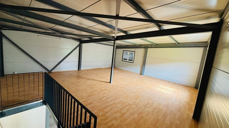 open floor with wooden planks, black railings, metal framework