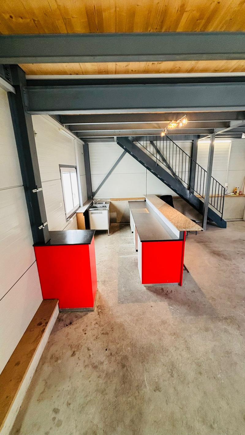 Raised ground floor, two red cupboards, metal stair, track lighting