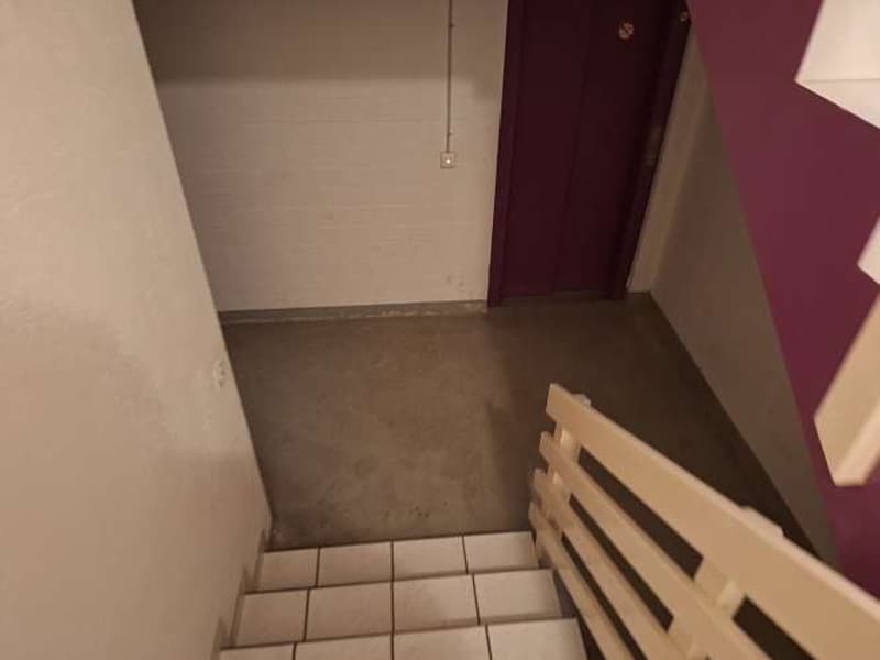 Entrance stairs to an apartment, light painted walls, tiled floor, white railings
