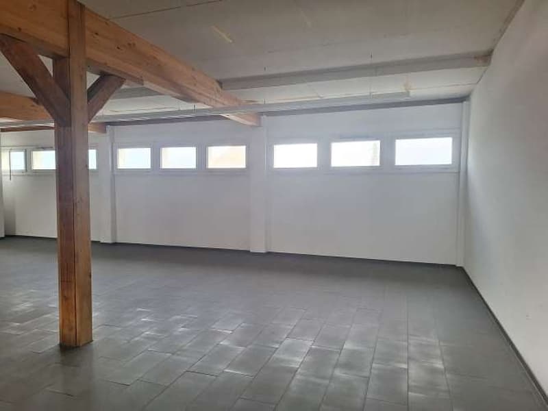 empty room, large windows, wooden beams, tiled floor