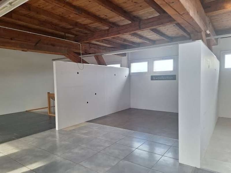 wooden ceiling, large open space, white walls, tiled floor, windows, wooden staircase