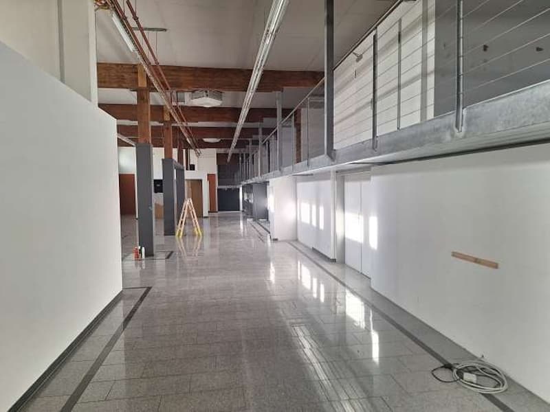 open room with tiled floor, wooden beam ceiling, open balcony, windows, unfinished walls