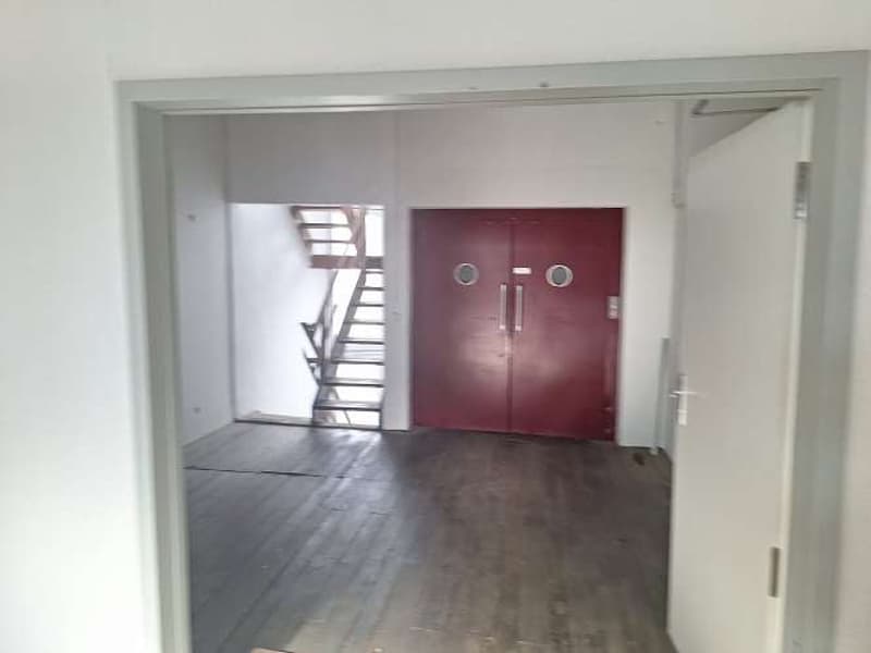 empty room, hardwood floor, red door, white walls, staircase