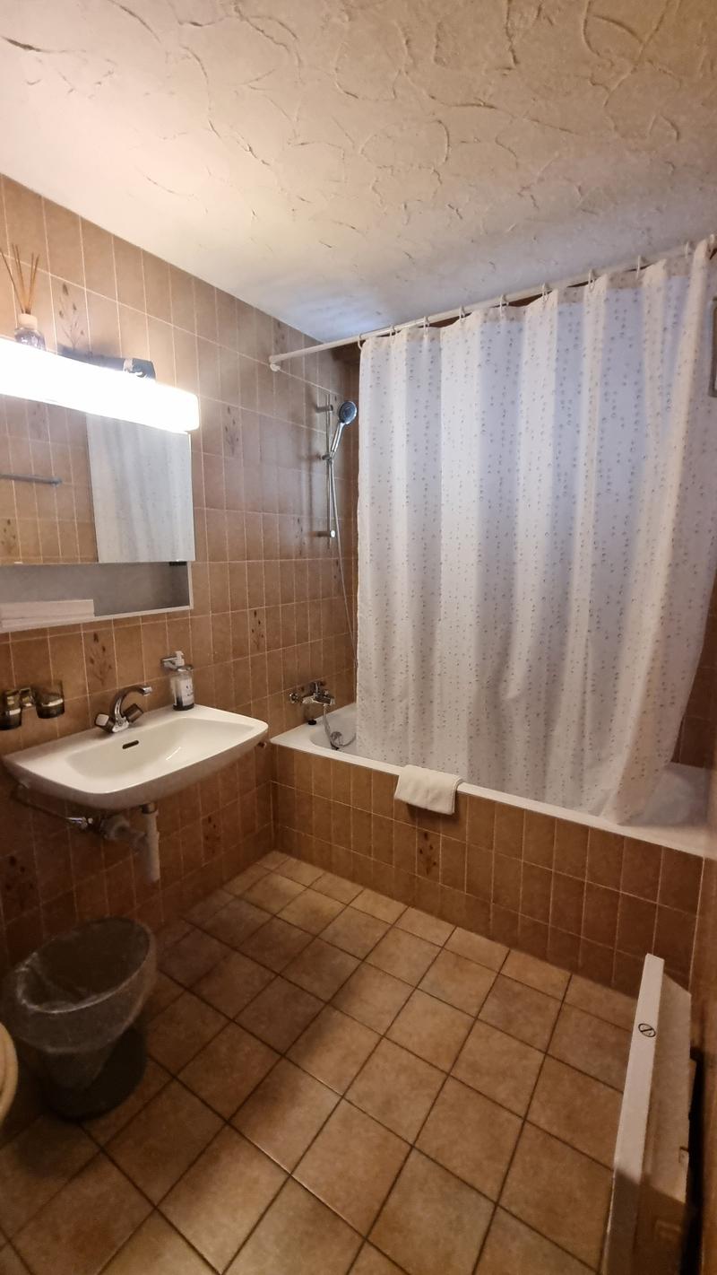 Bathroom, bathtub, sink, toilet, shower curtain, tiled floor, mirror, faucet, shower head