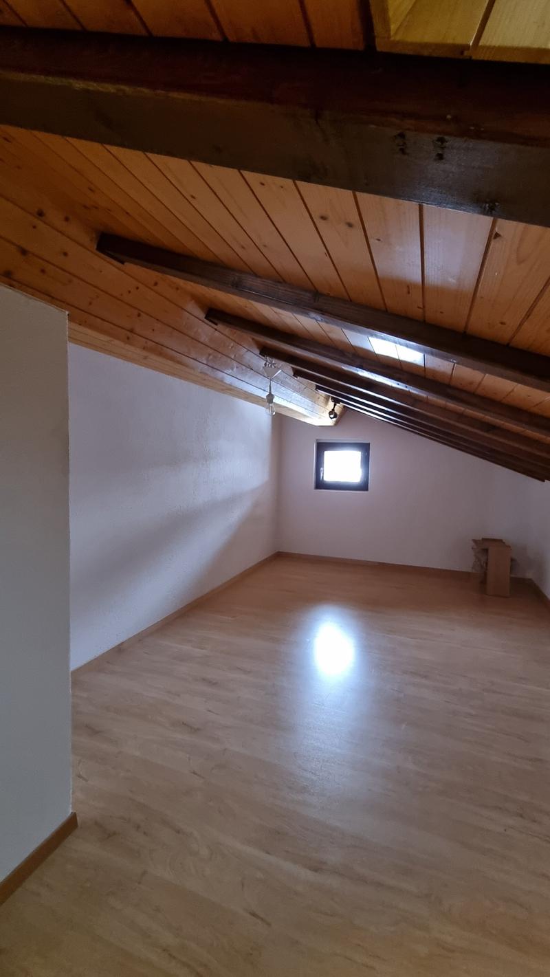 empty room with wooden floor and ceiling, white walls, small window