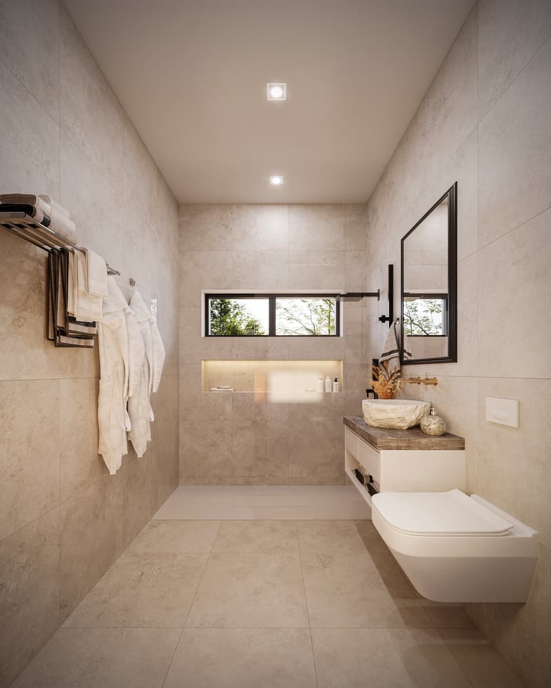 Spacious bathroom with beige tile walls and floors, a wall-mounted toilet, a vanity with a vessel sink, and a recessed shelf. There is a window providing natural light and a towel rack on the wall.