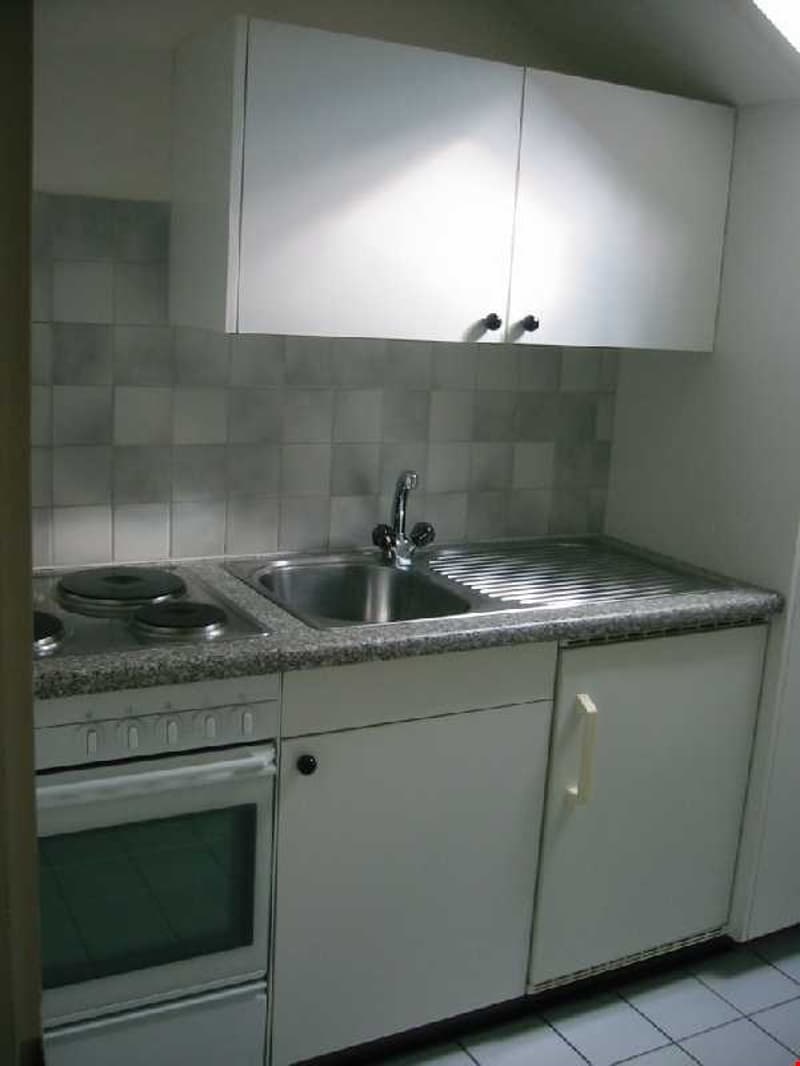 white kitchen with a sink, oven, and stove