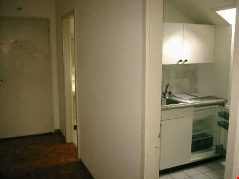 Small kitchen with white cabinets, sink, and a small oven