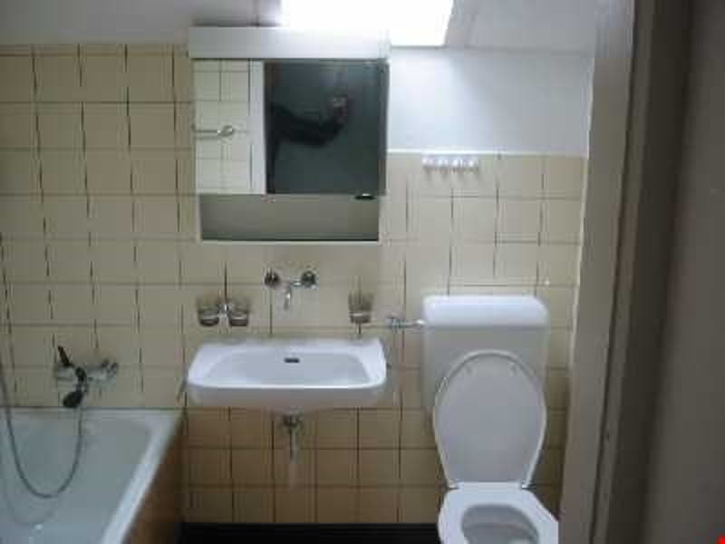Bathroom with bathtub, sink, toilet, mirror, tiled walls