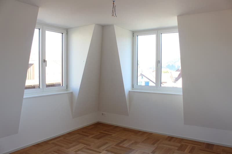 empty room, wooden floor, white walls, two windows, slanted ceiling