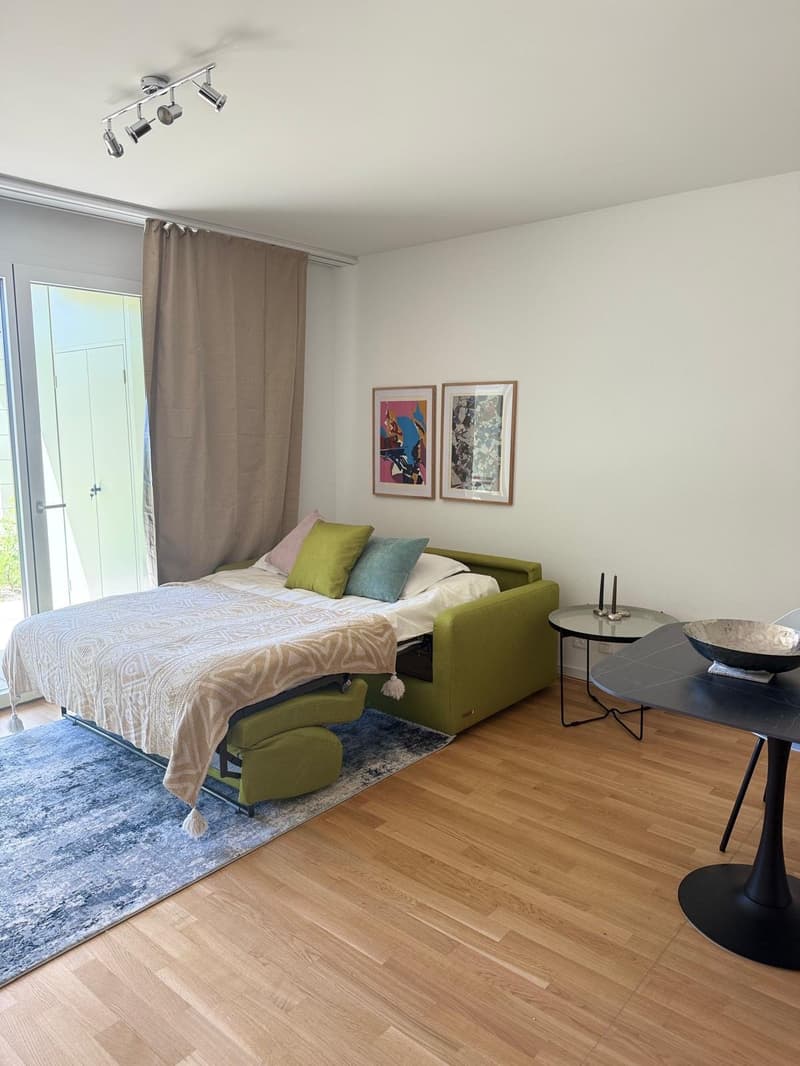 bedroom with bed, rug, table, artwork, curtains, lamps