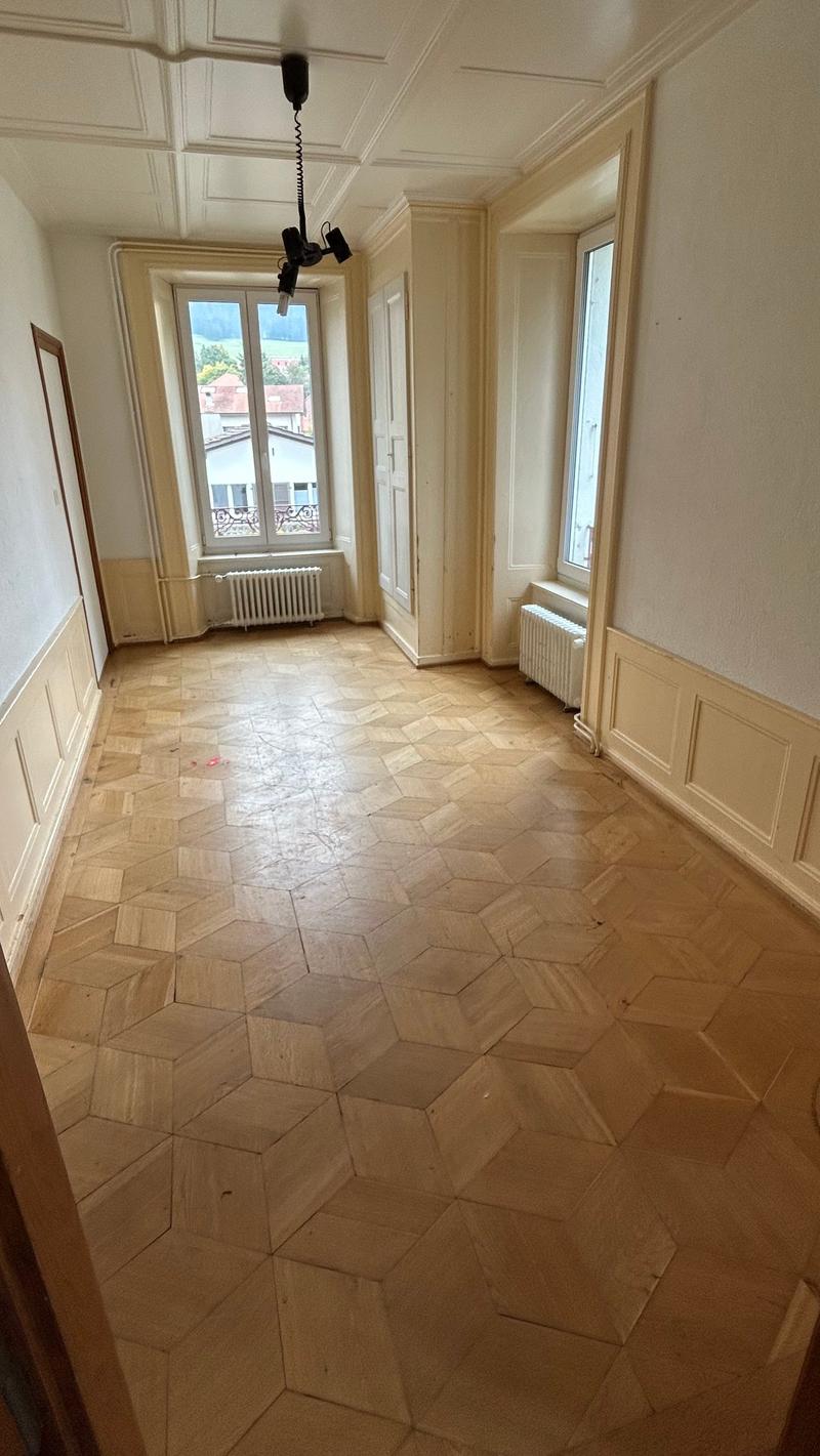 Parquet floor, large windows, radiators, hexagonal geometric pattern, empty room