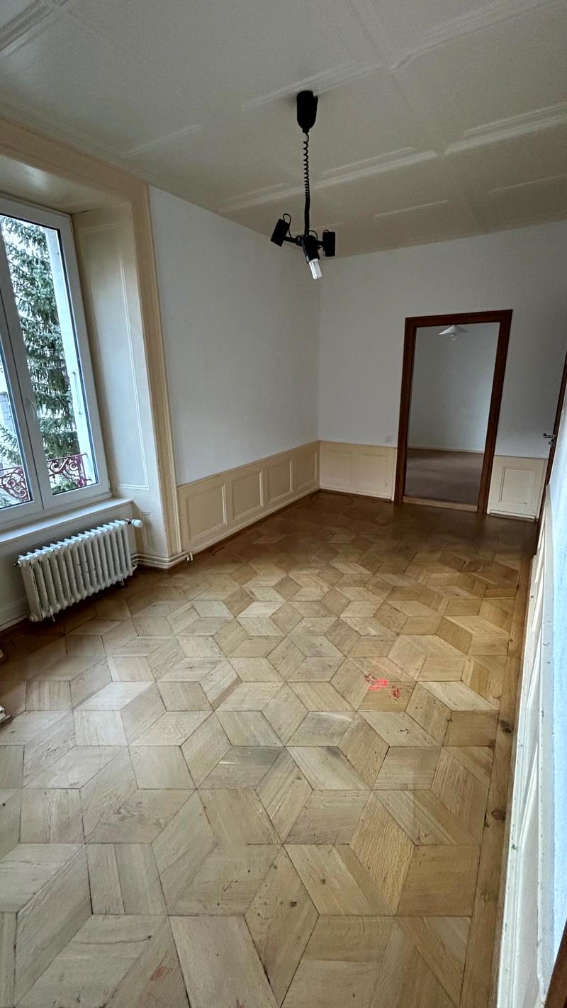 Empty room, parquet floor, large windows, radiator, mirror, door, chandelier