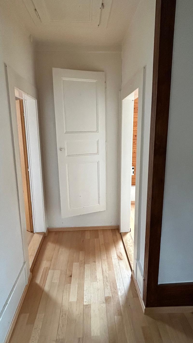 Hardwood floors, white walls, three doors