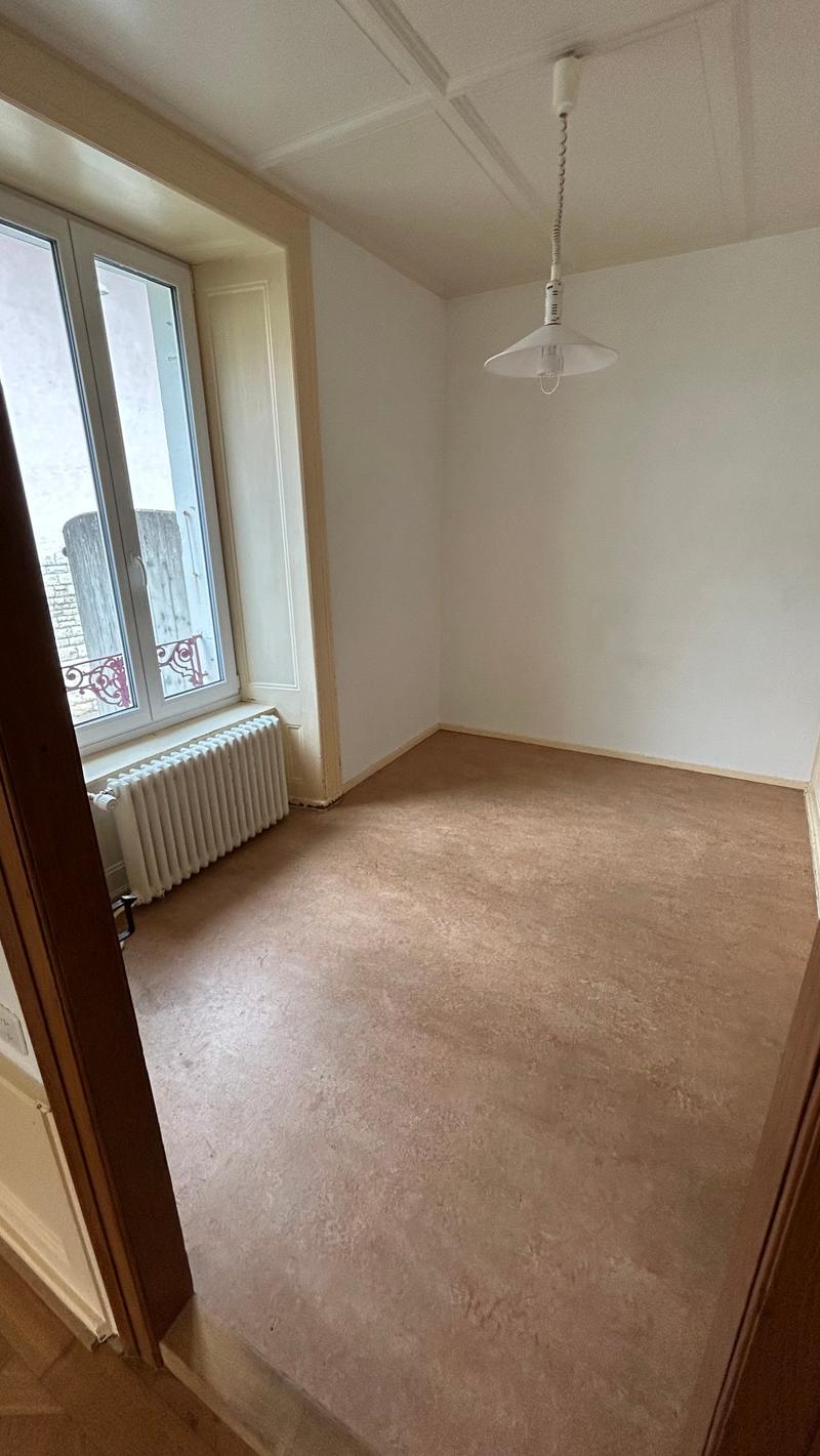 empty room with white walls, wooden floor, large window, hanging lamp, wall heater