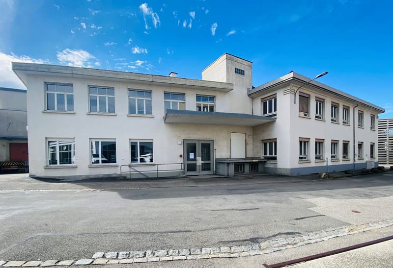 Two story commercial building, modern architecture, concrete construction, large windows, open parking area in front